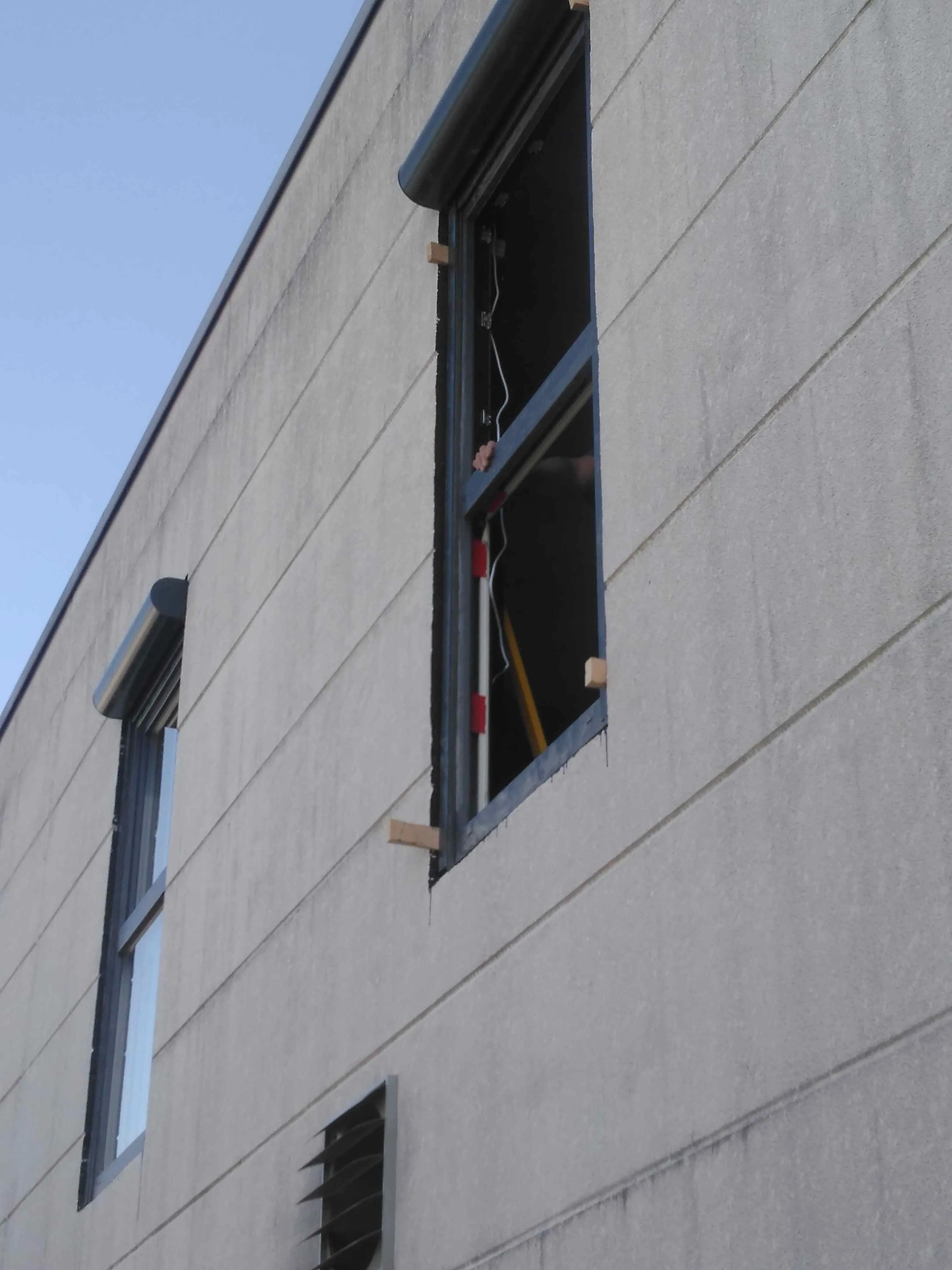 Fensterrahmen wird in eine Hallenfassade eingepasst